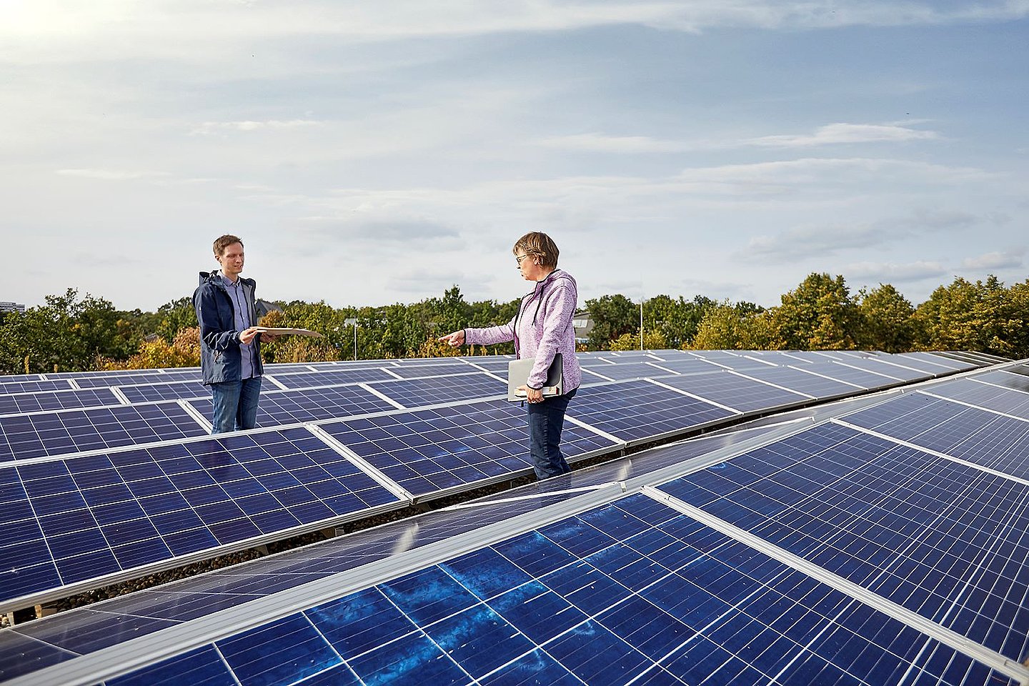 Zwei Personen stehen auf einem großen Dach mit einer Photovoltaik-Anlage. Foto: KEA-BW/AMX